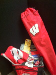 Safelite – Badger package- pair of tickets with parking pass to UW homecoming game, a flag, a cooler,          campchair, umbrella and poncho 